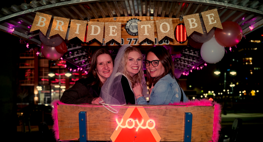 Bride and friends sitting on back bench of Brew Bike during Reno Bachelorette Party