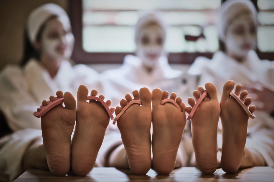 Three people getting facial masks and pedicures